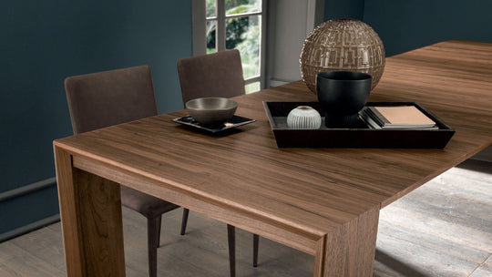 Goliath extendable dining table set with chairs, plates, and decorative items in a room.