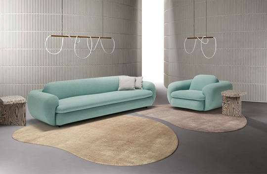 Light blue Space sofa and Space swivel armchair in a modern room with geometric rug and wall patterns.