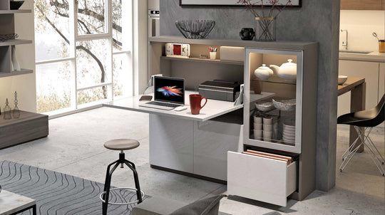 Modern kitchen with a home office in grey and white, laptop, mug, and decorative items.