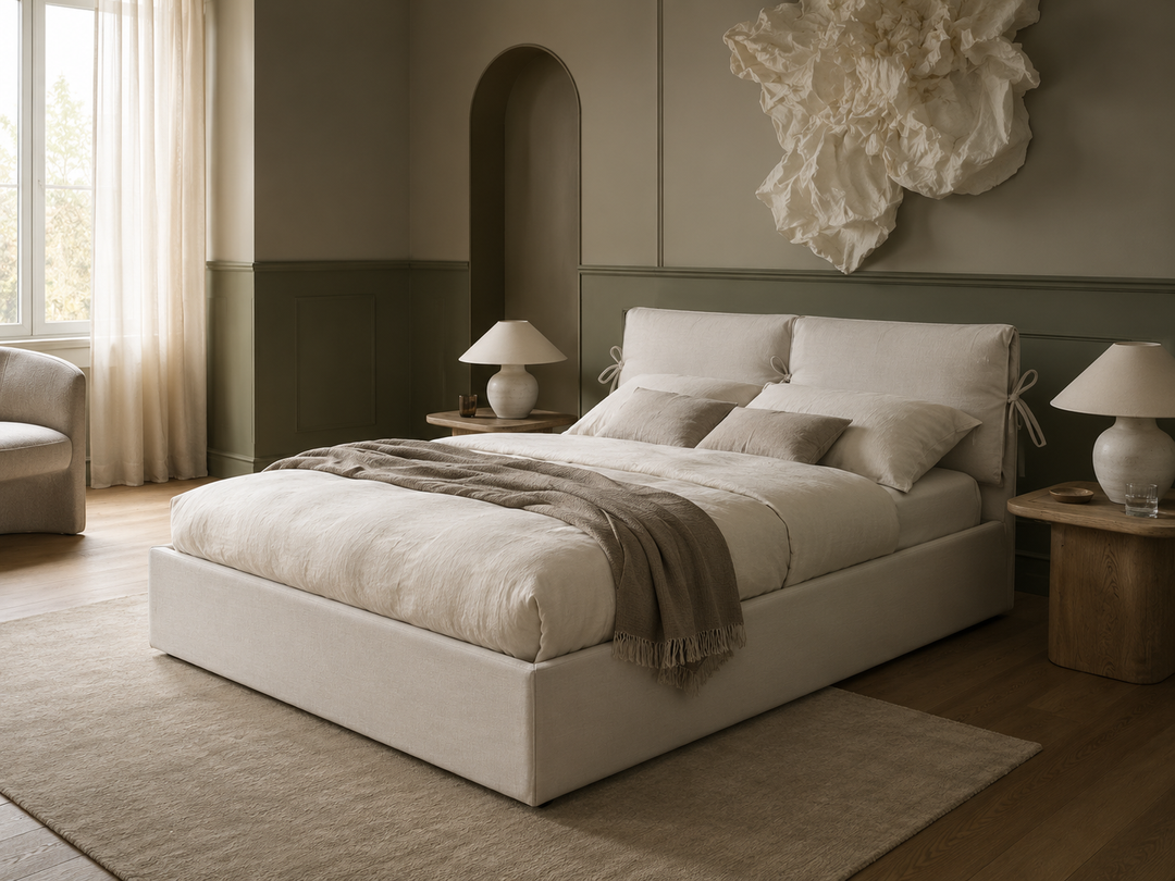 Cloude a modern storage bed with upholstered cream headboard and footboard, dressed in neutral beige bedding and a taupe throw blanket, styled in a minimalist, warm-toned bedroom.
