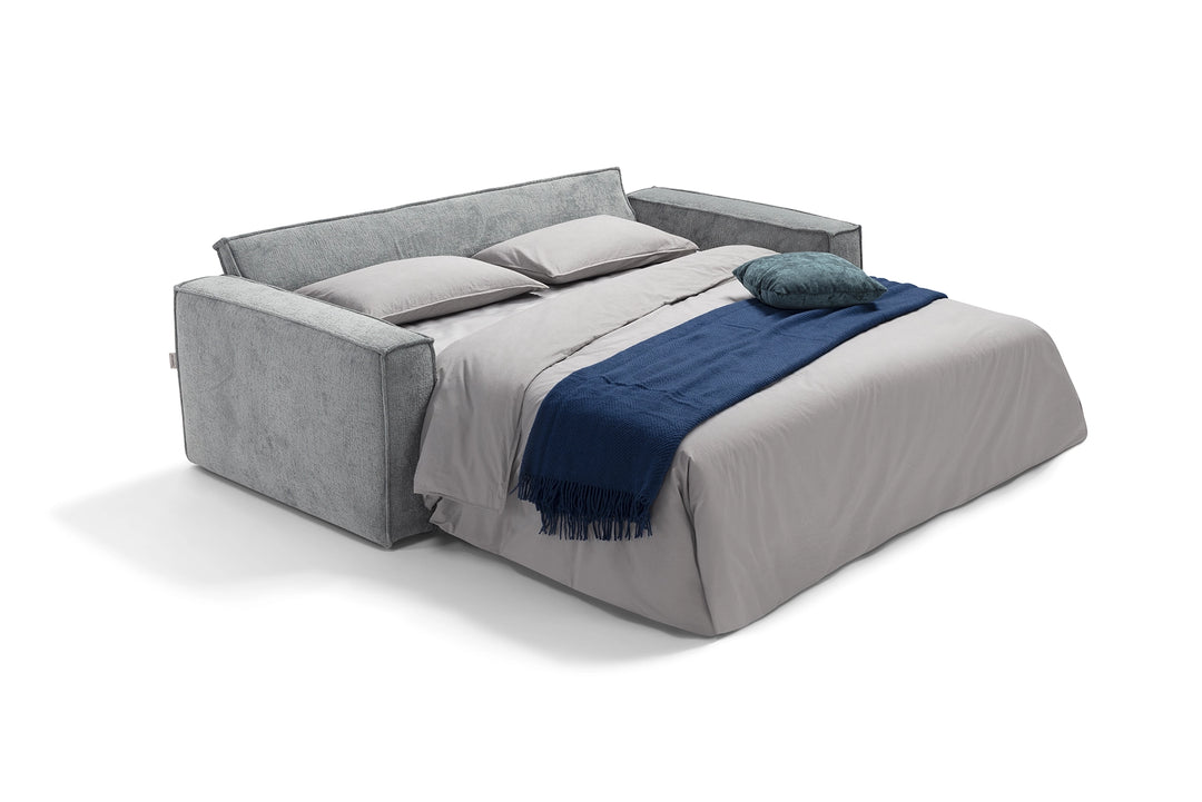 Grey upholstered bed with gray and blue bedding on a white background