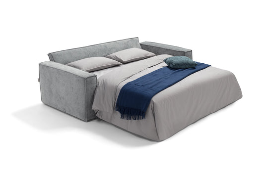 Grey upholstered bed with gray and blue bedding on a white background