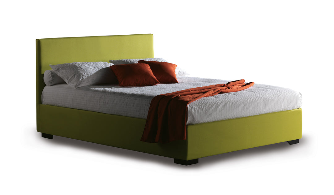 Malibu ottoman storage bed with green frame, white mattress, and red pillows and blanket on a white background