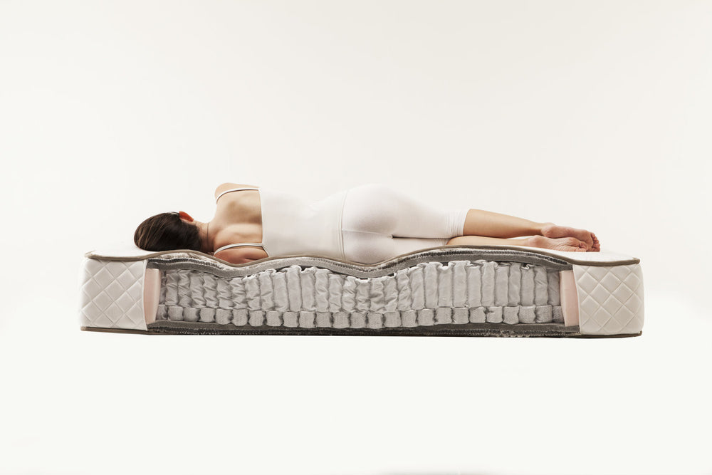 Person lying on a Superb mattress with a cross-sectional view showing its layers.